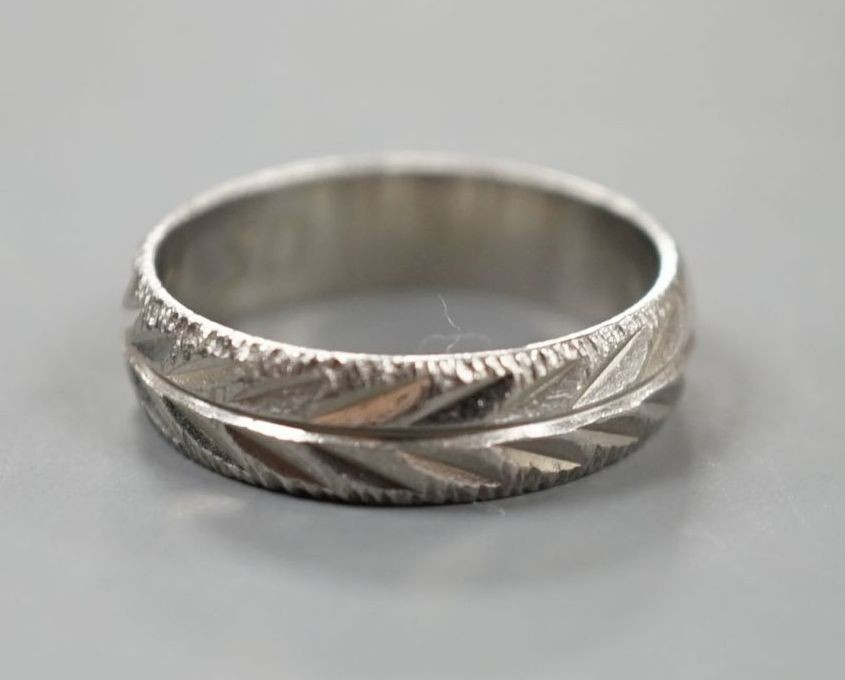 A modern bright cut engraved platinum wedding band, size K